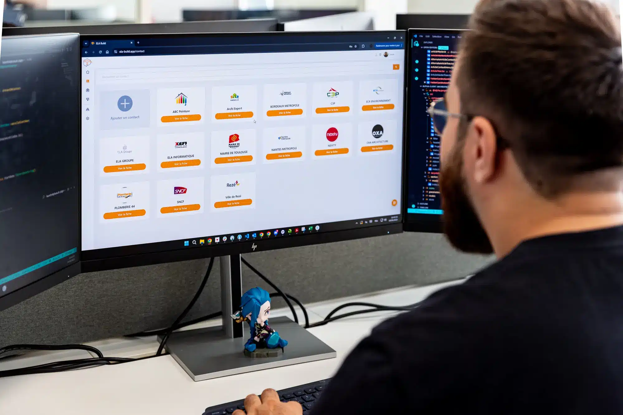 Écran double encadrant un développeur qui travaille sur une interface logicielle de gestion de projet, affichant des icônes et menus colorés. Écran double encadrant un développeur qui travaille sur une interface logicielle de gestion de projet, affichant des icônes et menus colorés.